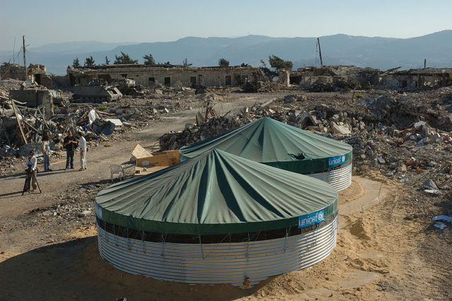 The prison ruins behind the UN tents. Author: Julien Harneis – CC BY-SA 2.0