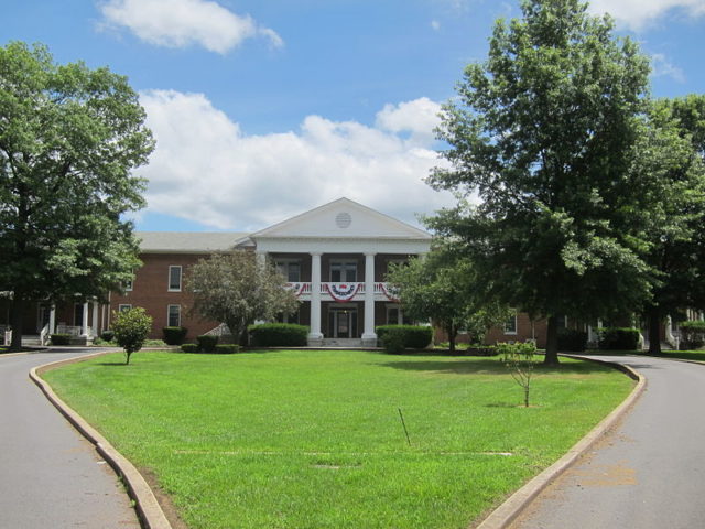 The central section (behind the portico) of the West Virginia Schools for the Deaf and Blind is the original building of the Romney Literary Institute. Author: Justin.A.Wilcox – CC BY-SA 4.0