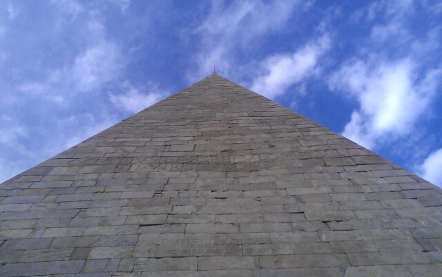 A view of a stone pyramid from the ground.