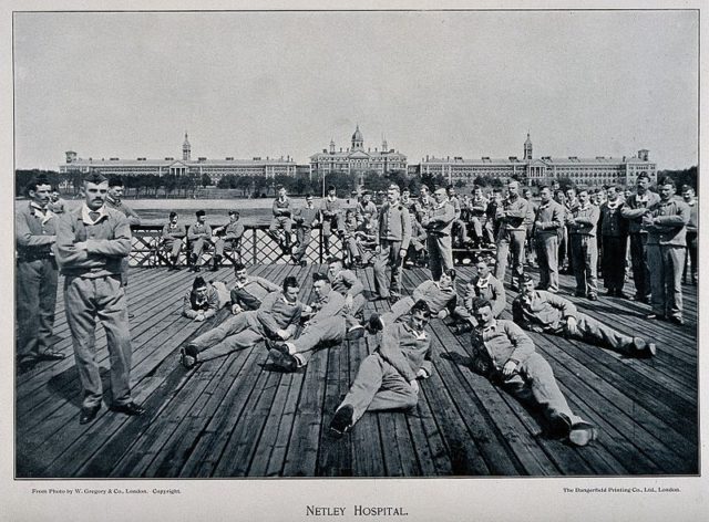 Soldiers relaxing with the hospital in the background. Author: Wellcome Images – CC BY 4.0