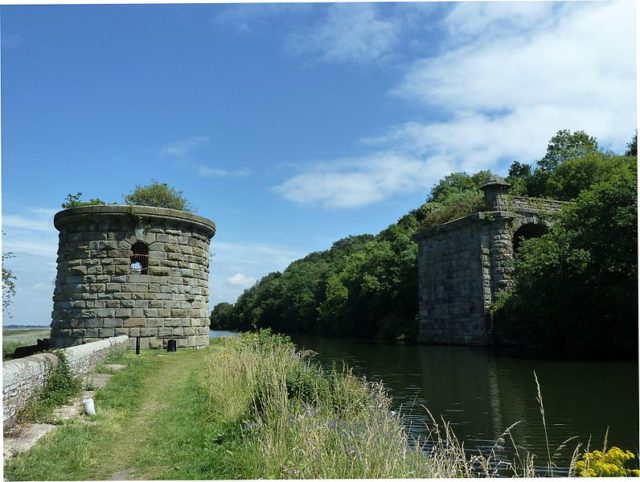 The central support for the swing bridge across the Gloucester & Berkeley Canal still survives, together with some of the masonry approach viaduct at the eastern end. Author: Andy Dingley – CC BY-SA 3.0