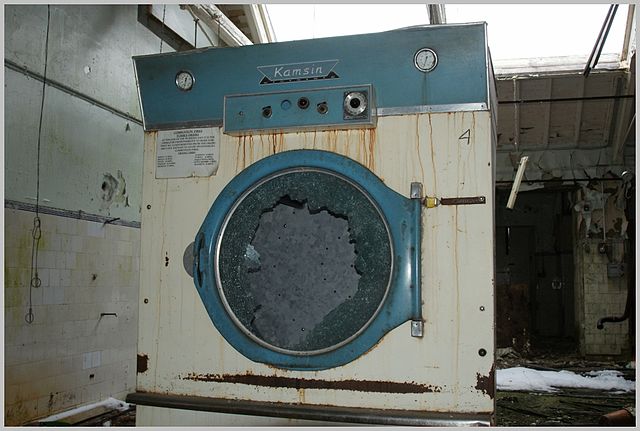 Rusty washing machine with a broken door