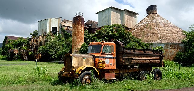 Truck parked near trees that line the exterior of the Old Sugar Mill of Kōloa