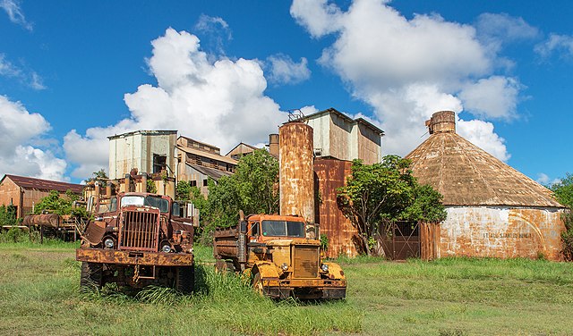 Two trucks parked outside of the Old Sugar Mill of Kōloa