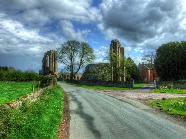 A road with stone ruins on the side.