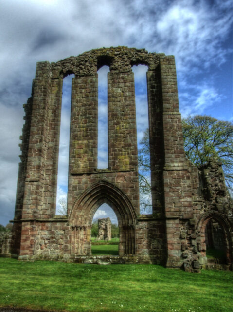 Stone ruins wall with three windows.