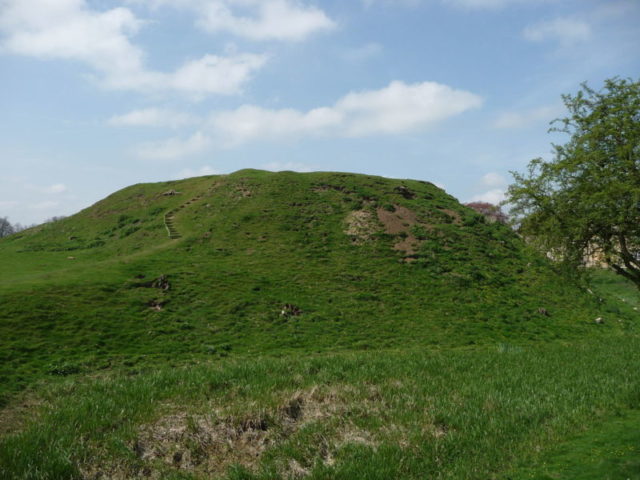 The motte and bailey castle was strategically placed beside a river crossing. Author: Iain Simpson CC BY-SA 2.0