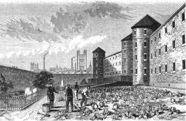 The burial grounds, where prisoners work under the view of guards. Author: Herbert Watkins – Public Domain