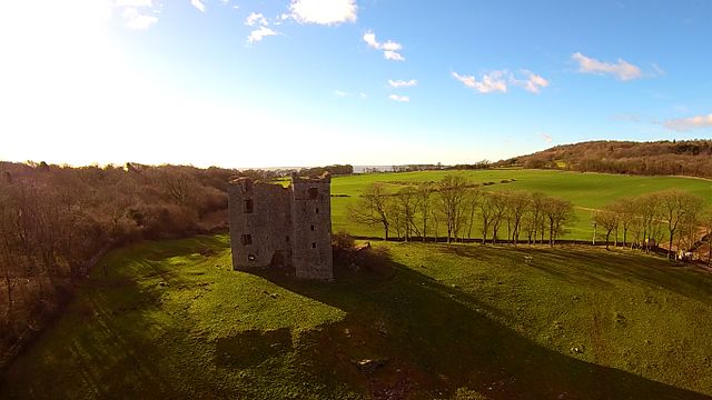 The tower site looking south-west toward the coast. The public footpath runs left to right behind the tower in this photo – Author: User:Anglovirtual – CC BY-SA 3.0