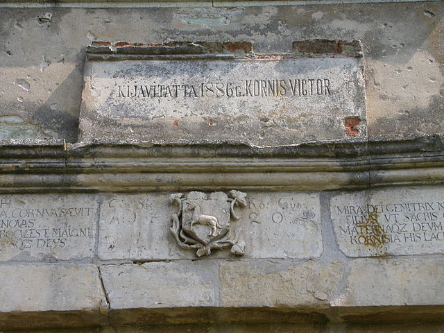 The memorial tablet and the unicorn hatchment (the coat of arms of the Kornis family) over the tower-gate. Author: Andrei kokelburg – CC BY-SA 3.0 ro