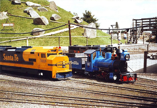 Two miniature locomotives parked on railway tracks