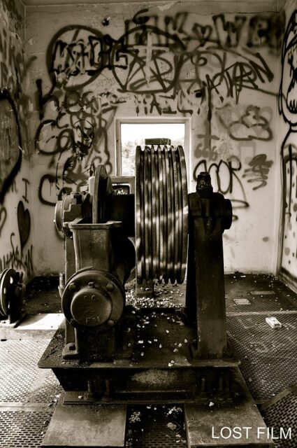 Piece of machinery in the middle of graffiti-covered room