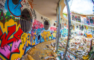 Graffiti-covered walkway strewn with debris