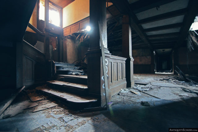 Dark hallway leading to a spiral staircase