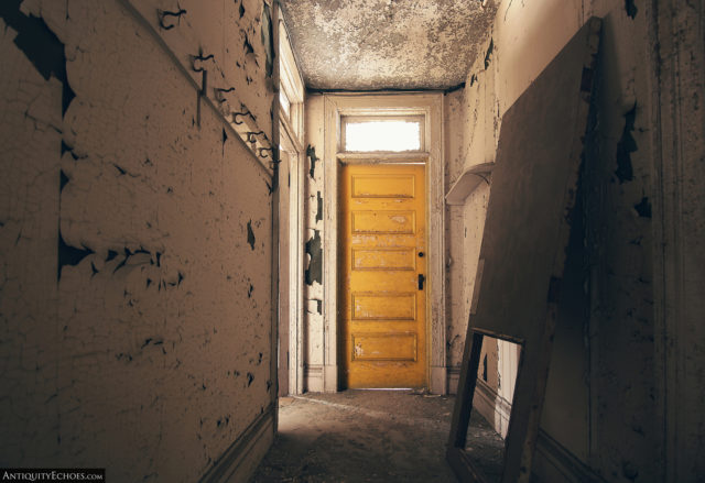 Entry hallway with a door at the end and coat hooks along the walls