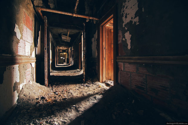 Hallway covered in dirt and with decaying walls