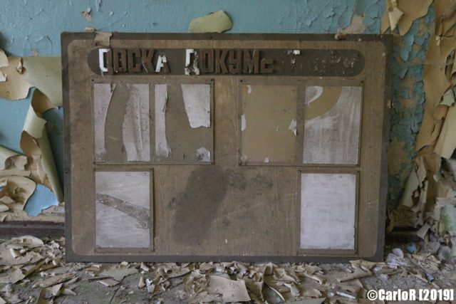 Cork board with old papers pinned to it