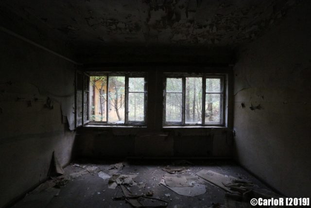 Darkened room dimly lit by two large windows