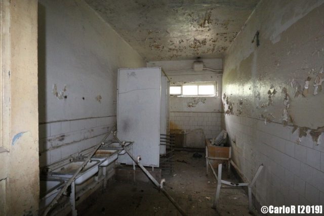 Decaying room with sinks along the wall