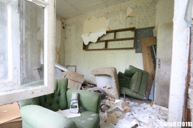 Deteriorating room scattered with debris and old furniture