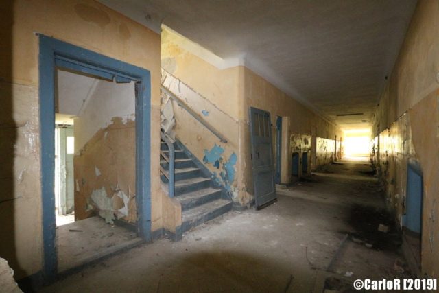 Hallway with an open doorway and staircase on the left side