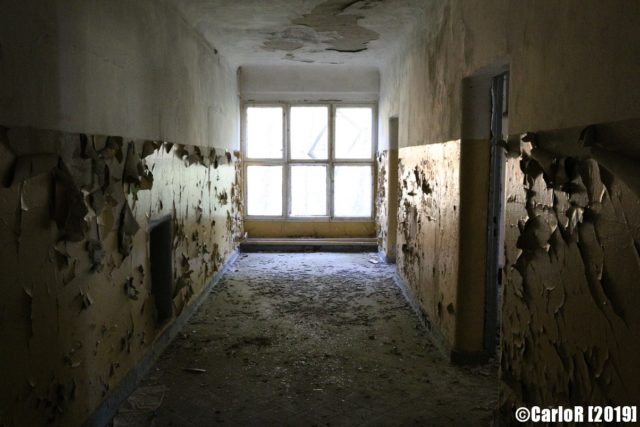 Deteriorated hallway lit by a large window