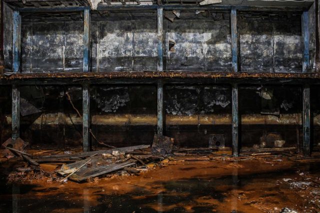 A flooded room filled with rust-colored water.