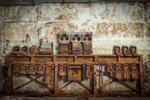 Rusty radar equipment placed against a concrete wall