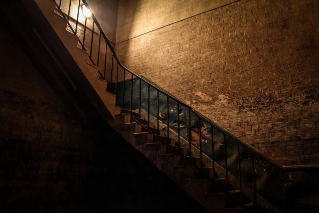 View of a darkened staircase from below.