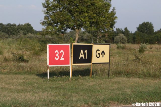 Red, black and white signs outside of Tököl Airbase