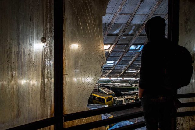 Person looking out a broken window