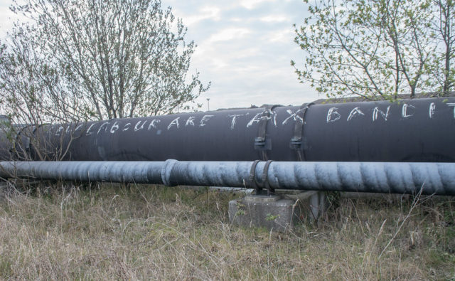 Metal oil pipe with graffiti written on it