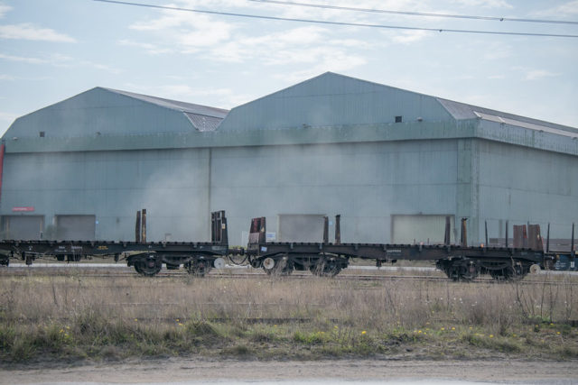 Railway cars in front of steel buildings