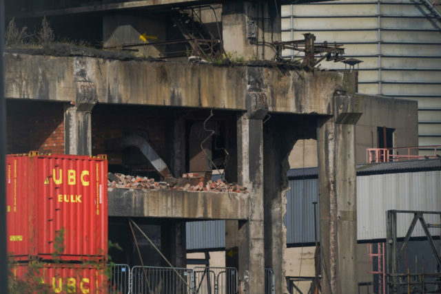 Exposed concrete building with metal containers around it