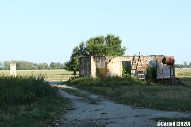 Gravel road beside a concrete building at Kalocsa Airfield