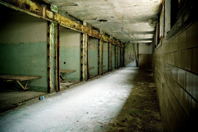 Open cells along a dimly-lit hallway in Eastern State Penitentiary's death row
