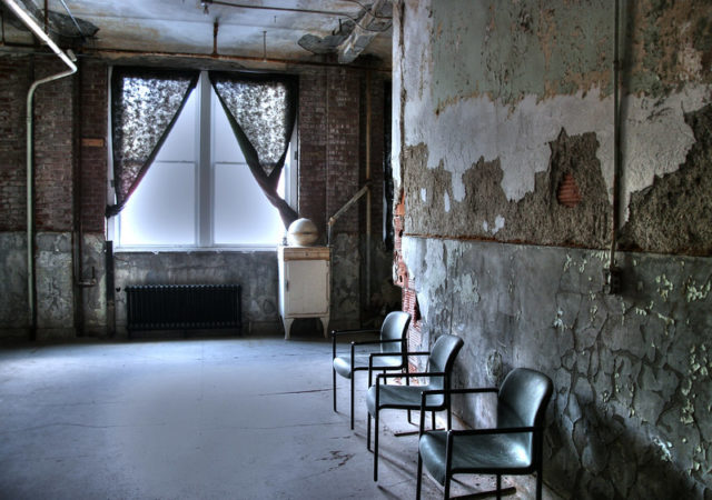 Chairs against the wall of a room lit by a large window