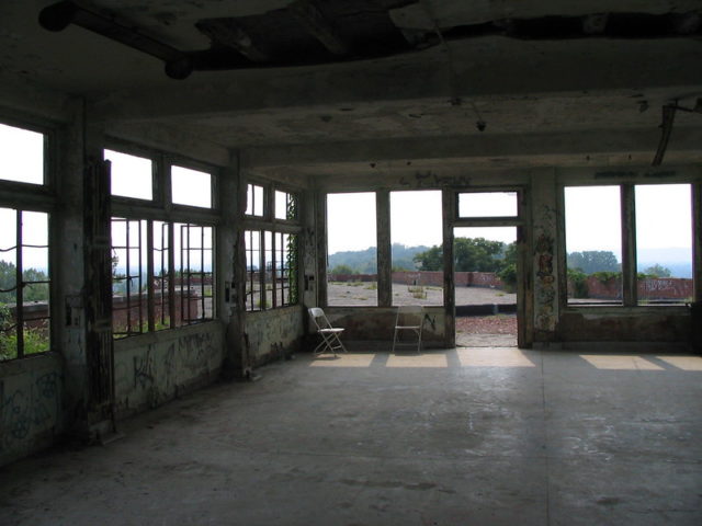 Dark room lit by numerous windows