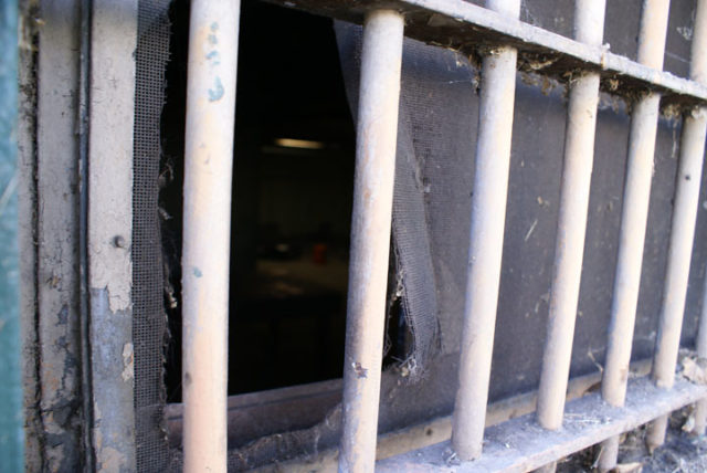 Broken window covered with metal bars