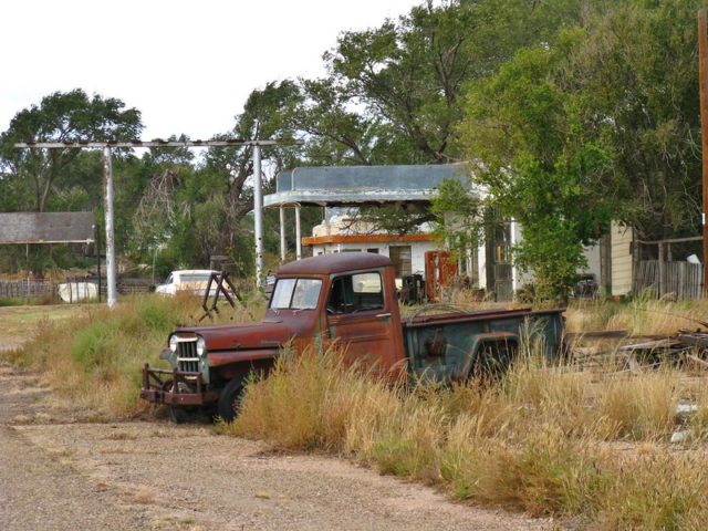 Rusy truck parked in tall grass