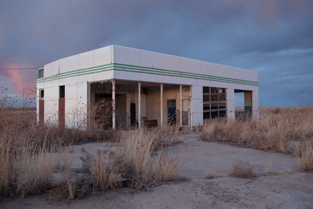 Abandoned service station at sunset