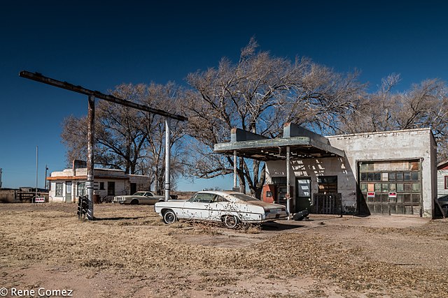 Vintage car parked in front of a Glenrio service station