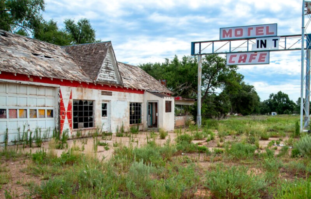 Abandoned motel with a deteriorating road sign