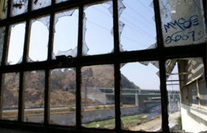 View of the exterior of Lincoln Heights Jail from a broken window pane