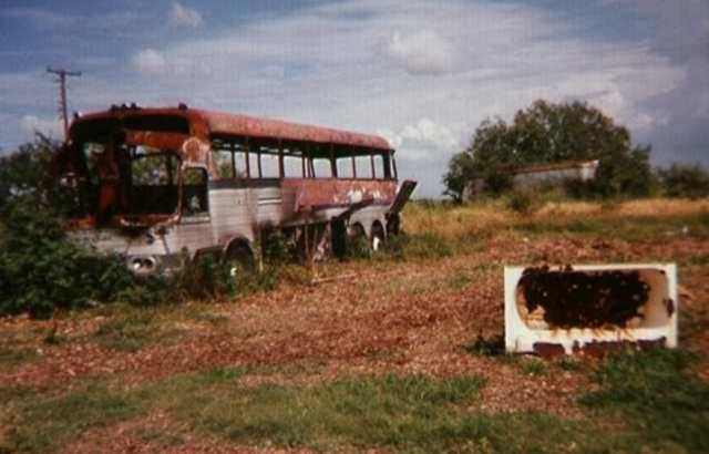 Burnt out bus in dying grass