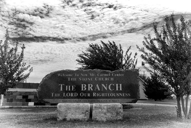 Stone entrance sign atop two rock at the Mount Carmel Center compound