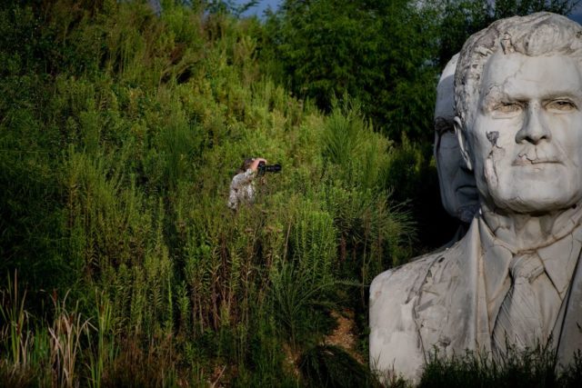 Woman taking a photo of the busts from Presidents Park