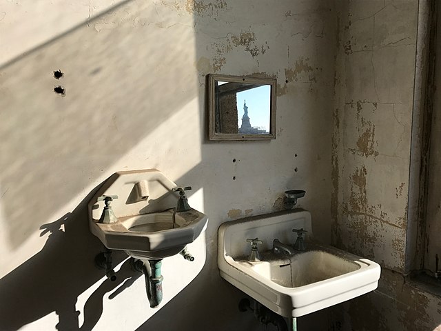 Two bathroom sinks and a mirror along a wall