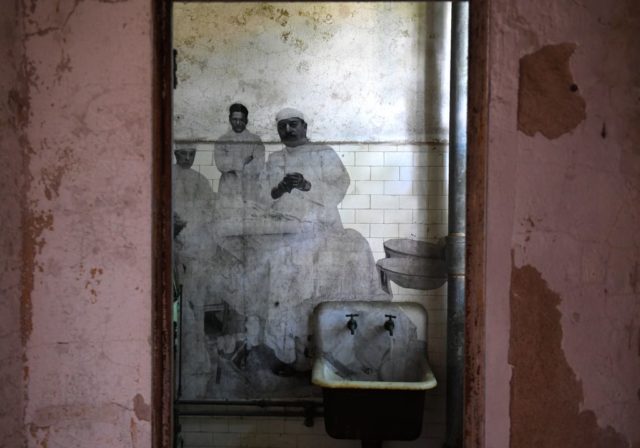 Photographs of immigrants on the bathroom wall at the Ellis Island Immigrant Hospital