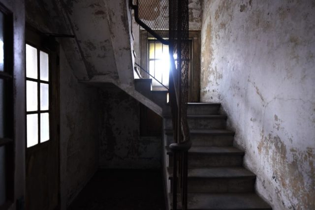 Darkened staircase lit only by two small windows
